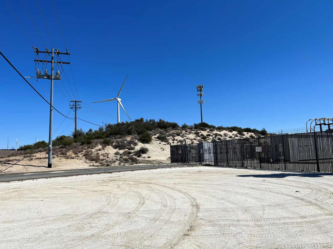 Utility poles, wind turbines, and a rural communications site.